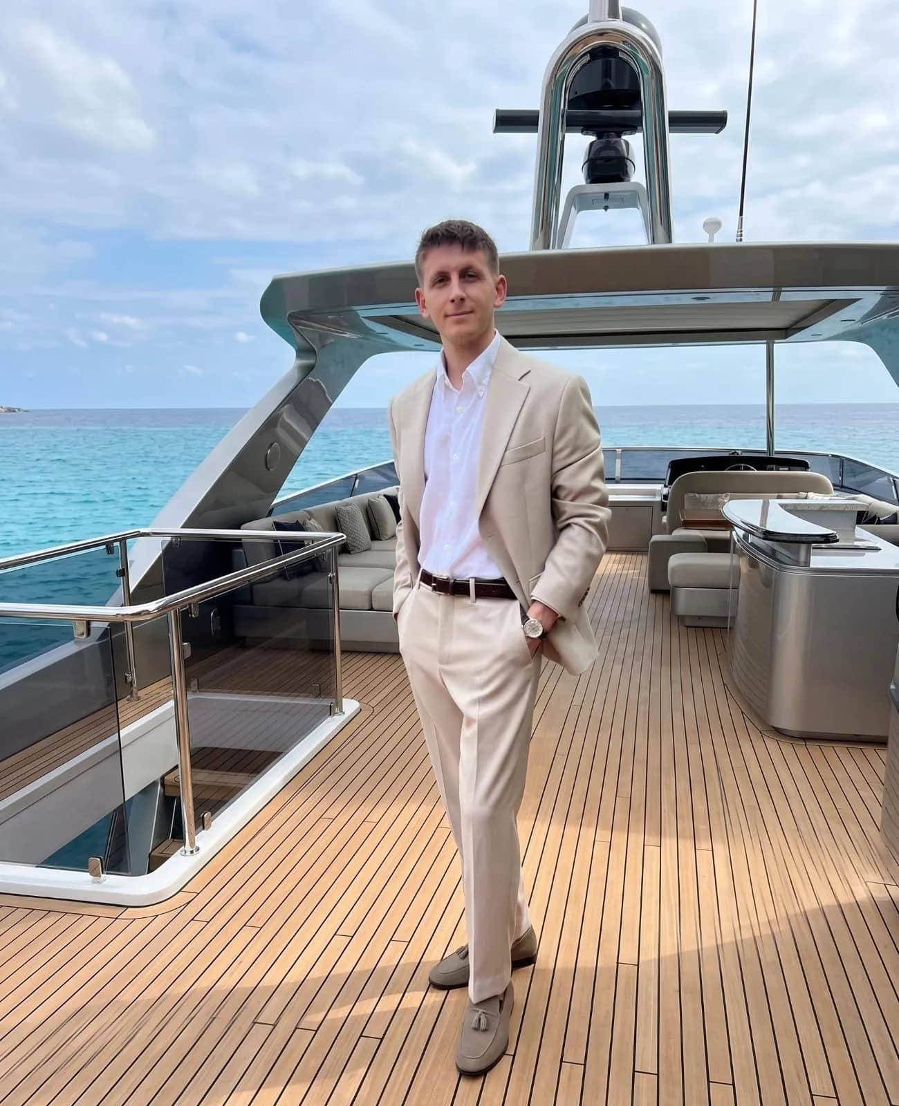 Gentleman in a beige linen suit on the flybridge of a motor yacht